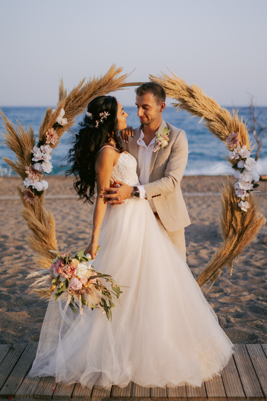 Bride and groom in front of an arch at their beach wedding in Gran Canaria