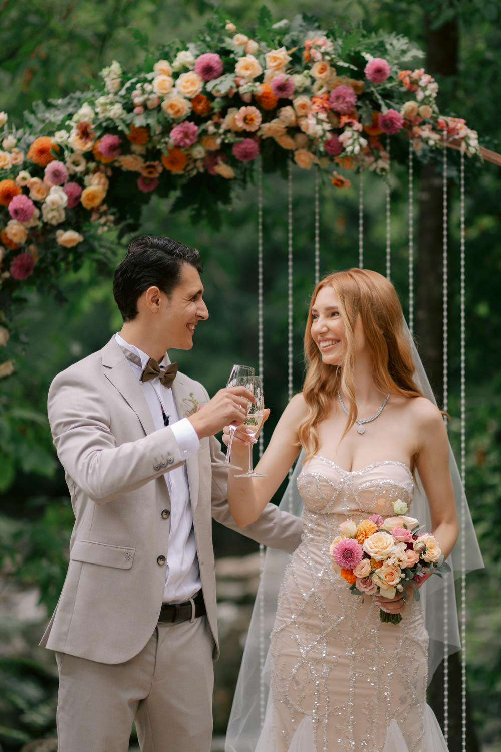 Just married couple looking inlove and clinking glasses after their garden ceremony in the Canary islands